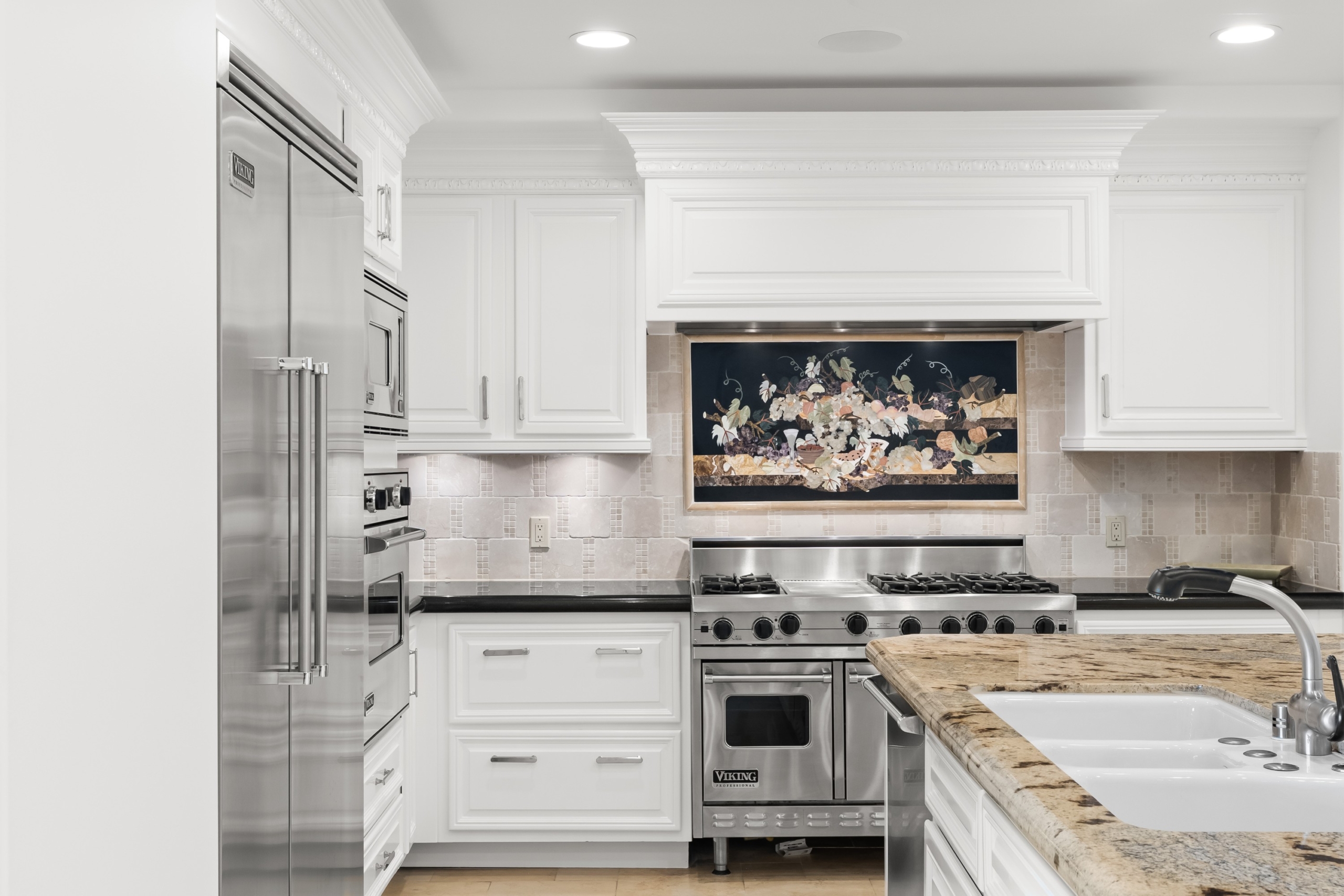 Kitchen at Residence 305 — Viking range, white cabinetry, granite island