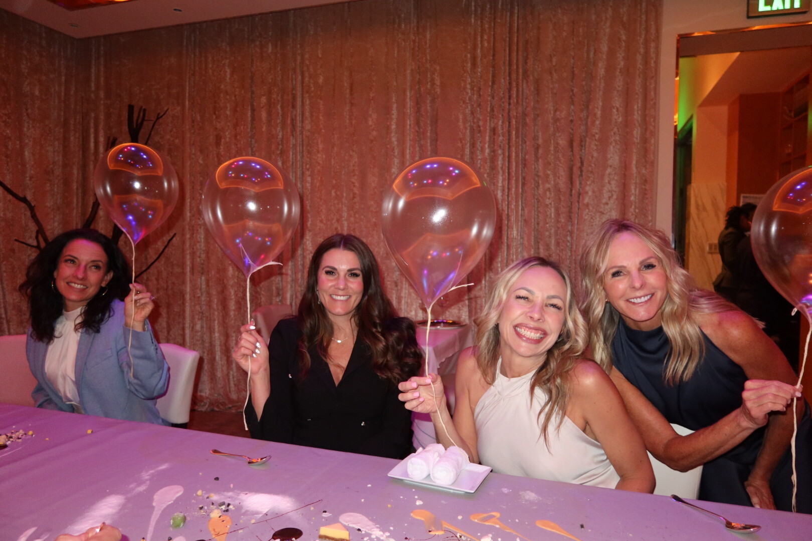 Four friends holding Alinea’s signature edible helium balloons at the Bellagio pop-up