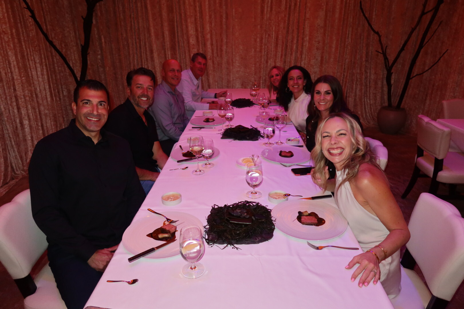 A group of eight friends around a long table at the Alinea pop-up restaurant inside the Bellagio in Las Vegas