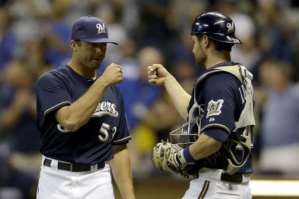 Brandon Kintzler pitching for the Milwaukee Brewers about 15 years ago, fist-bumping his catcher