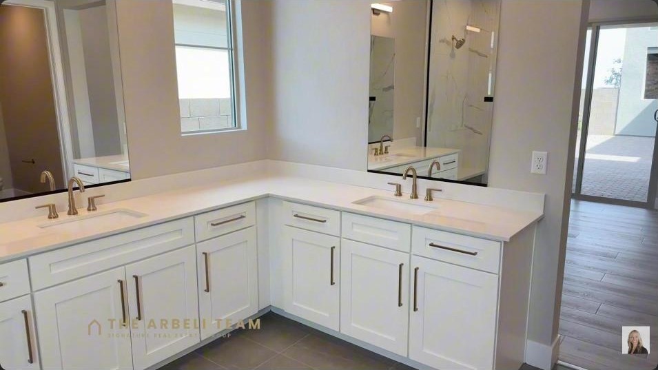Primary spa bath with a double vanity and walk-in shower in a new construction Grand Park home