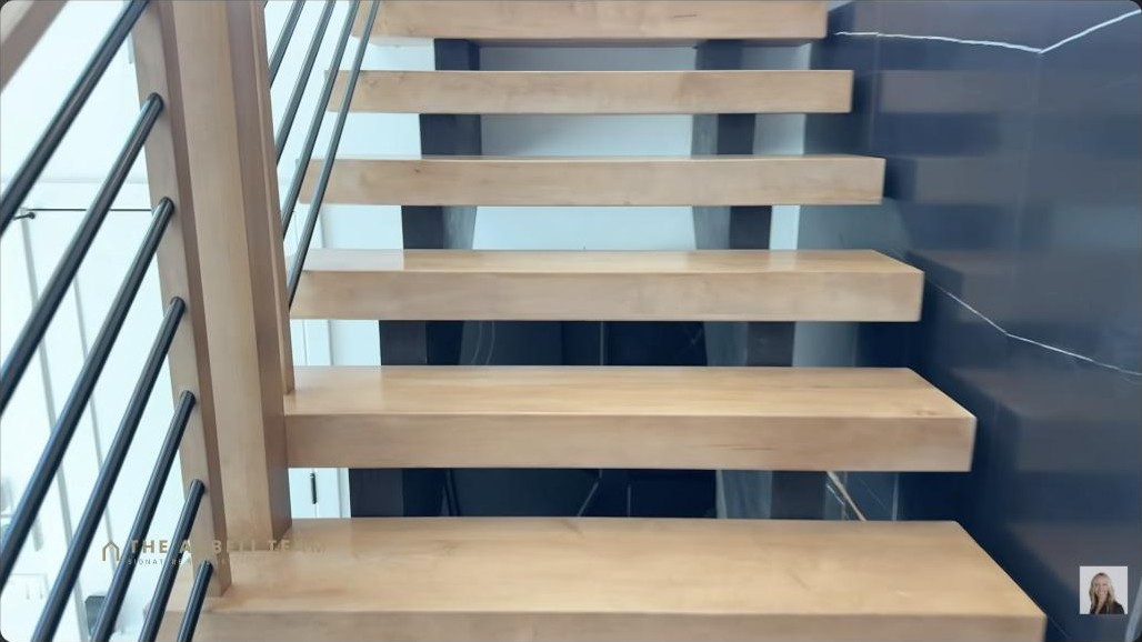 Modern floating wood staircase with glass railing in a new-construction Kestrel Village Summerlin home