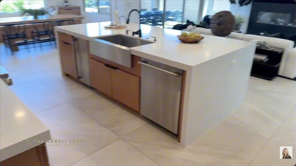 Gourmet kitchen with a large white waterfall island and farmhouse sink in a Kestrel Village Summerlin home