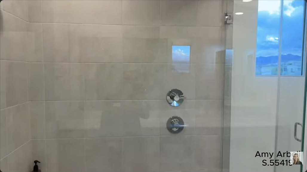 Walk-in shower with a mountain-view window in a modern Summerlin home in Redpoint