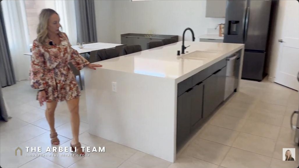 Two-tone kitchen with a navy waterfall quartz island in a Redpoint Summerlin West home