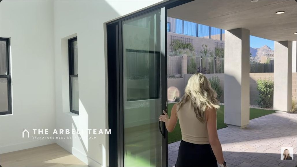 Covered loggia and backyard with stacking glass doors at a Summerlin 4-car garage home