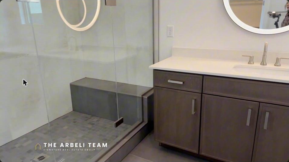 Primary bathroom with an oversized walk-in shower and LED mirrors in a Summerlin Grand Park home