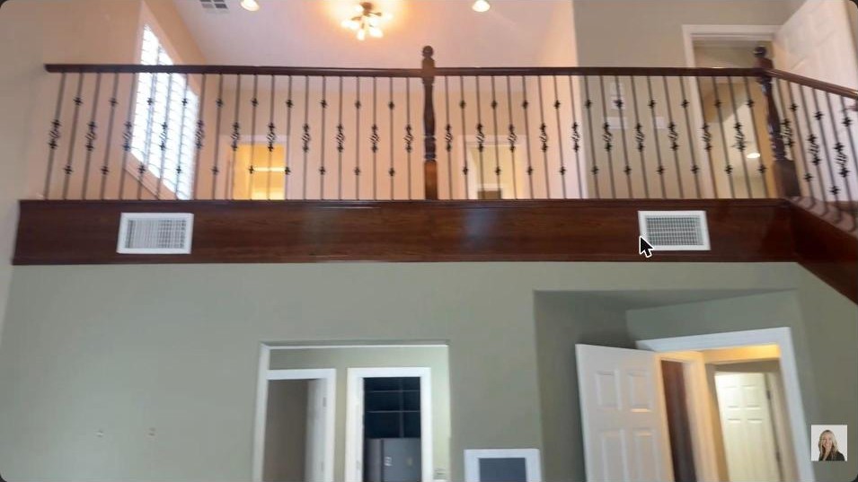 Two-story primary bedroom with an overhead loft and iron railing in a Summerlin West casita home