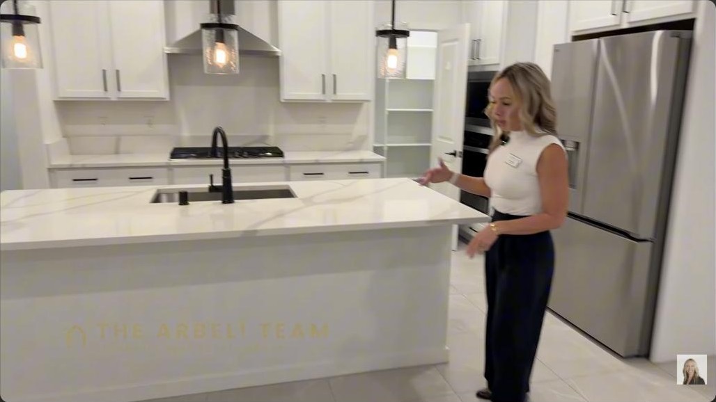 Kitchen island with quartz counters and a farm sink in a Reverence Summerlin townhome