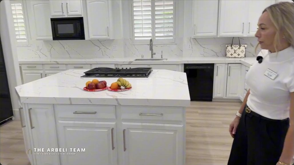 Large square marble kitchen island with a five-burner cooktop in a Summerlin luxury estate