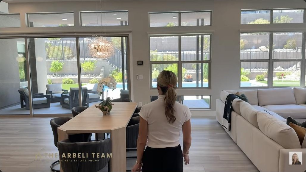 Open-concept great room and dining with a wall of windows to the pool in a single-story Summerlin West home