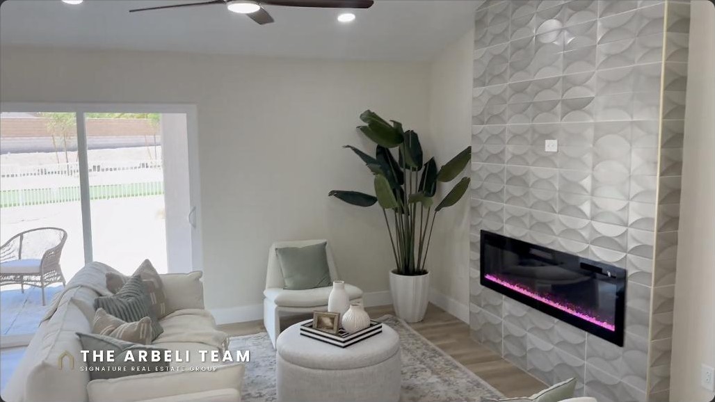 Renovated great room with an electric fireplace and feature wall in a single-story Del Webb Weston