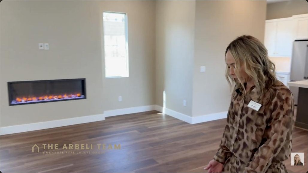 Open great room with a linear electric fireplace in a Tri Pointe home at Grand Park in Summerlin