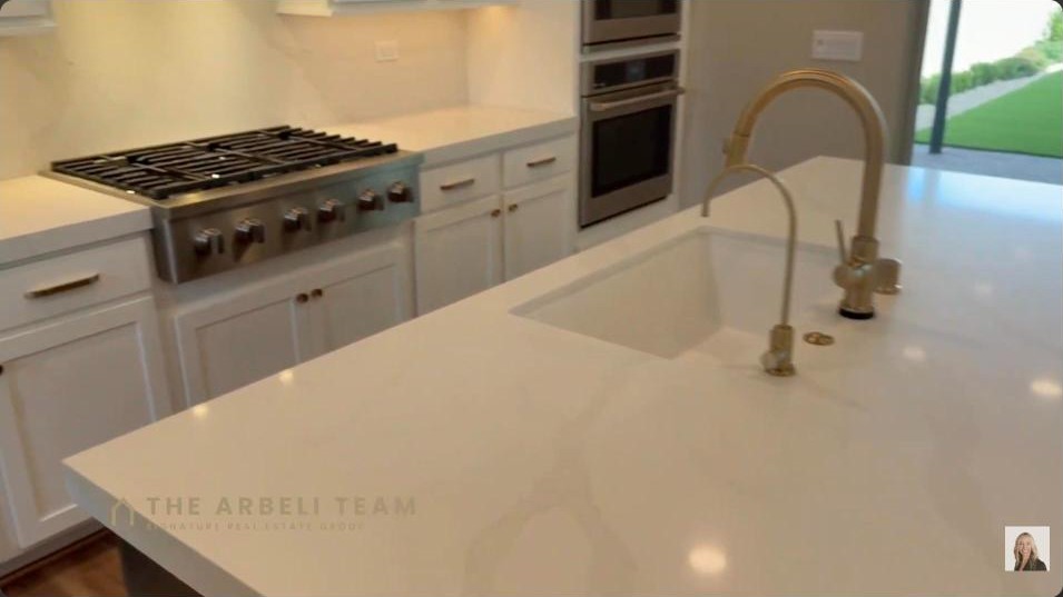 Modern kitchen island with gas cooktop and double ovens in a Tri Pointe home at Grand Park Summerlin