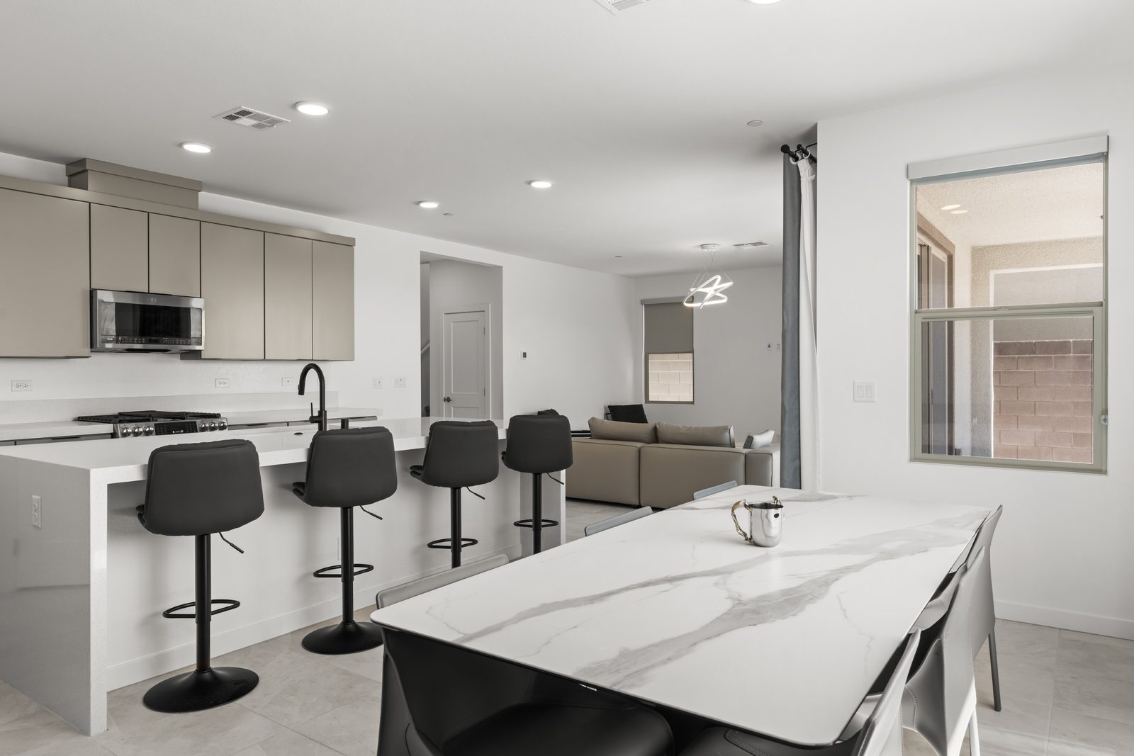 Kitchen with waterfall-edge quartz island, custom cabinetry and stainless appliances