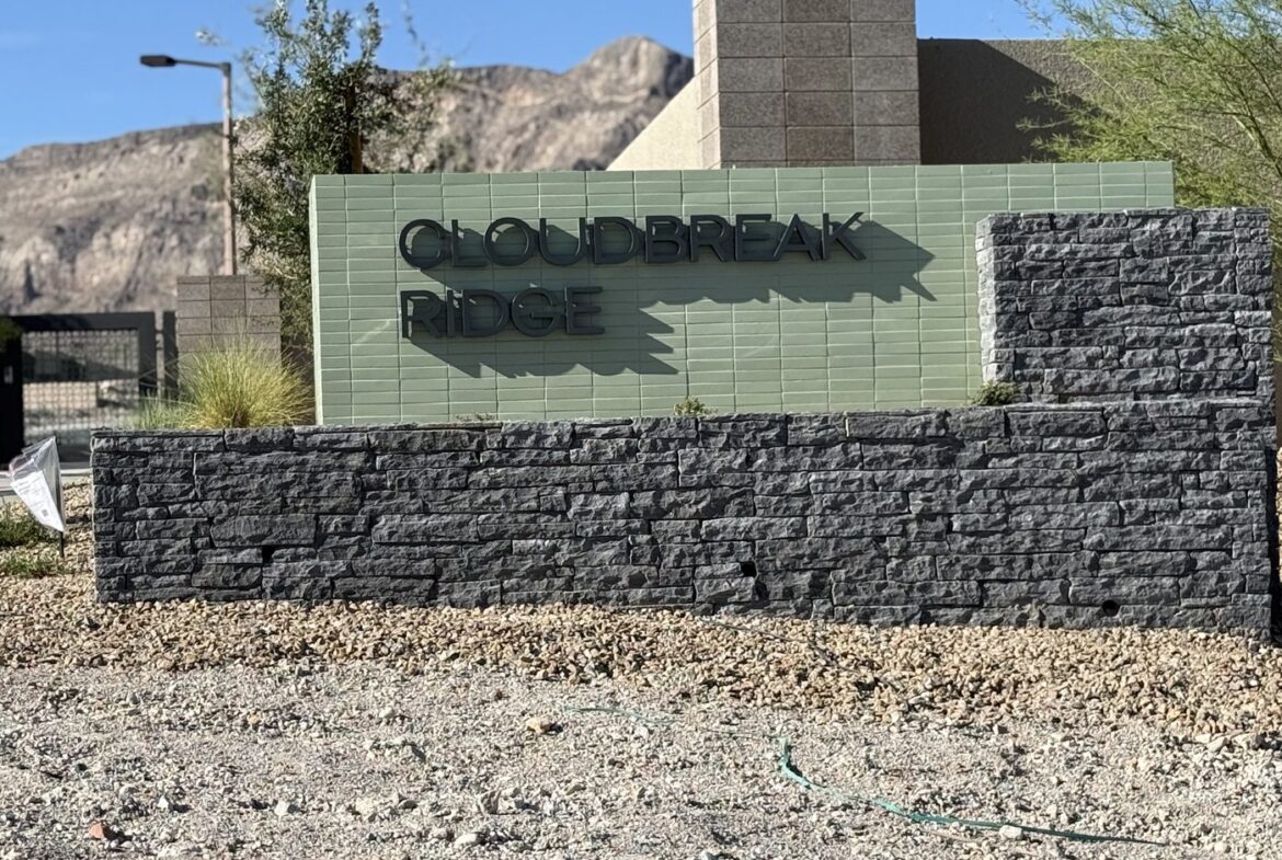Stone entrance monument reading Cloudbreak Ridge at the KB Home neighborhood in the La Madre Peaks village of Summerlin West, Las Vegas, Nevada, with a rocky mountain ridge behind it