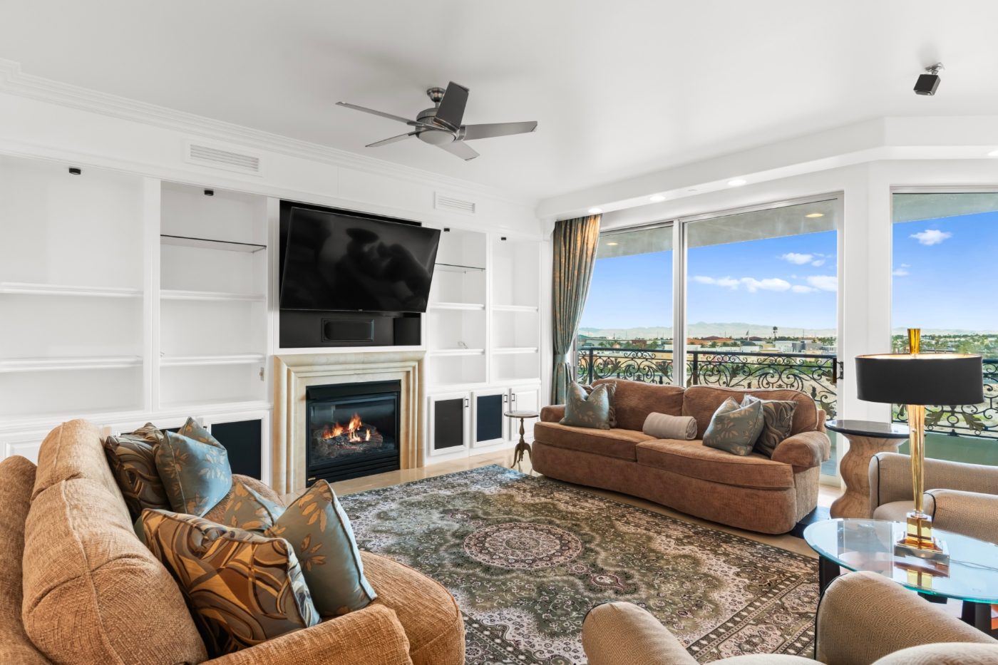 Living room with a fireplace and valley views through floor to ceiling windows in a Las Vegas high rise residence