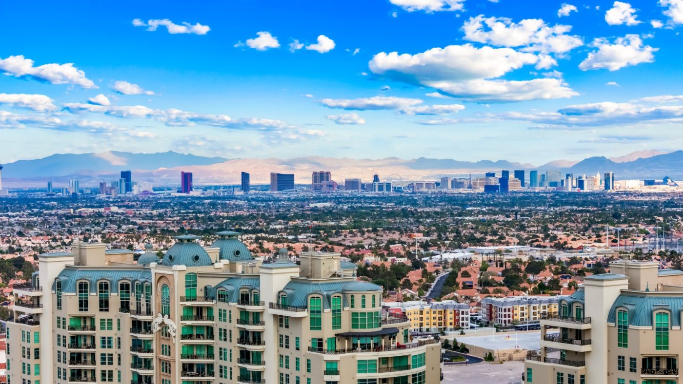 The Las Vegas Strip skyline seen across rooftops with the mountains behind, viewed from Summerlin