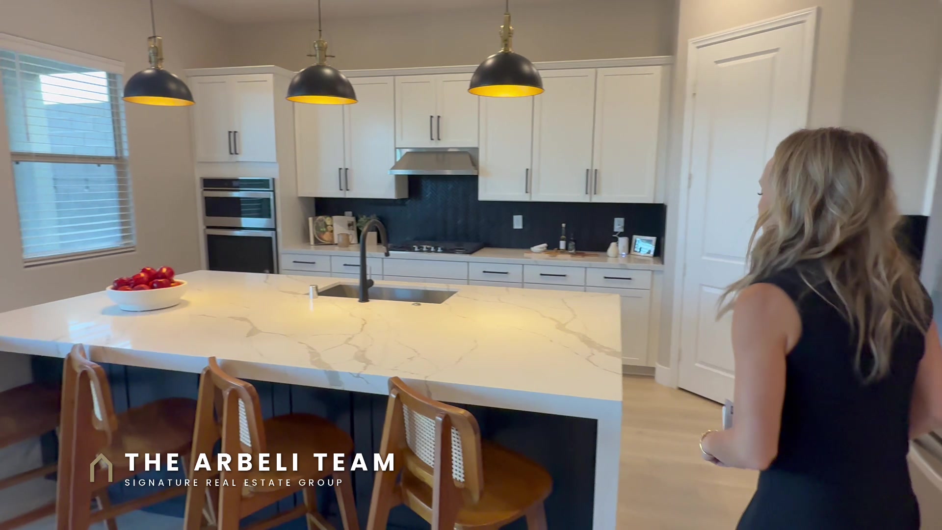 Upgraded kitchen with quartz island and designer pendants in a Stonebridge Summerlin home