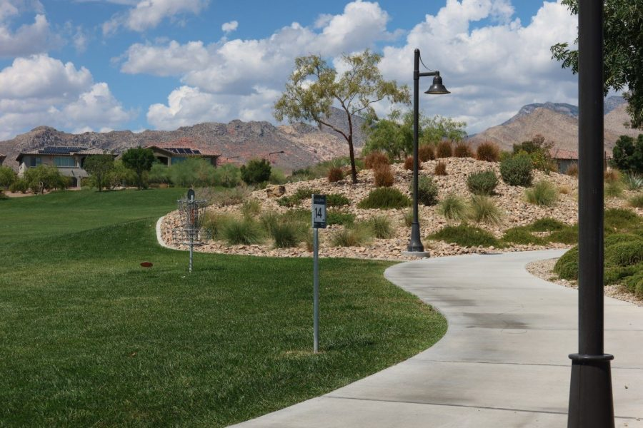 A walking path through a park in The Paseos, Summerlin, with the Red Rock escarpment behind it