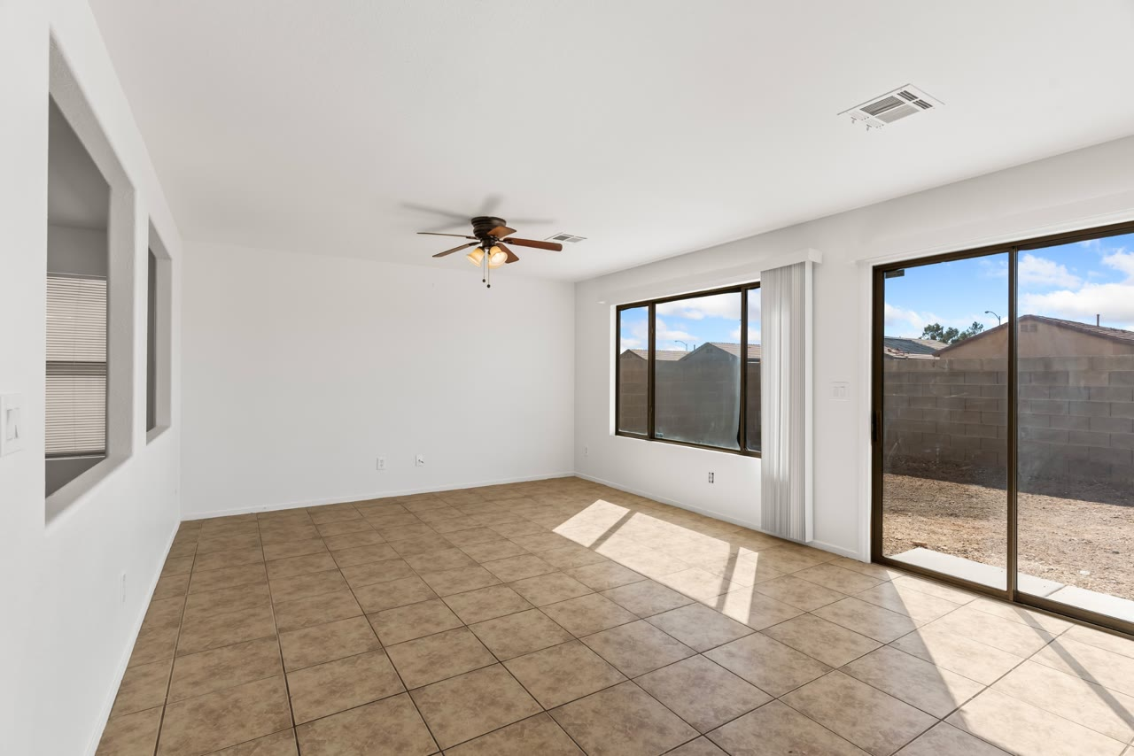 Great room with ceiling fan and slider to the backyard at 4655 Gracemont Avenue, Blue Diamond Ranch, Las Vegas