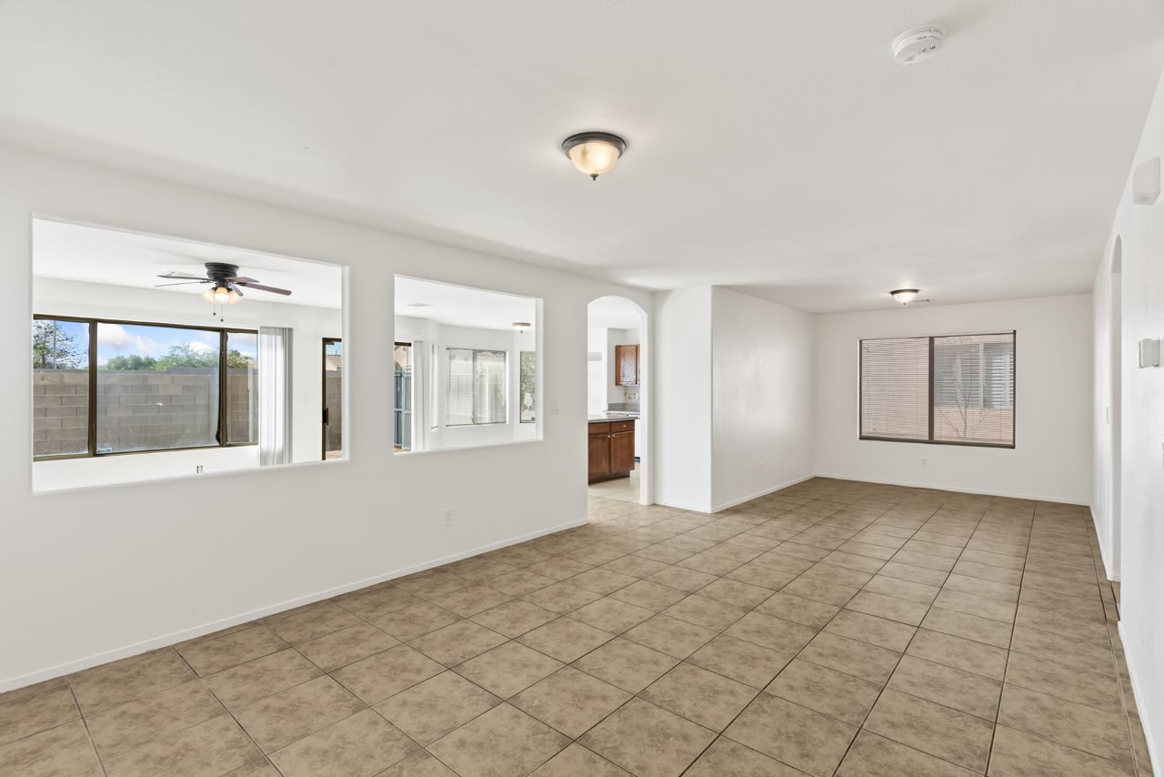 Living and dining rooms with tile floors and arched walkways at 4655 Gracemont Avenue, Blue Diamond Ranch, southwest Las Vegas