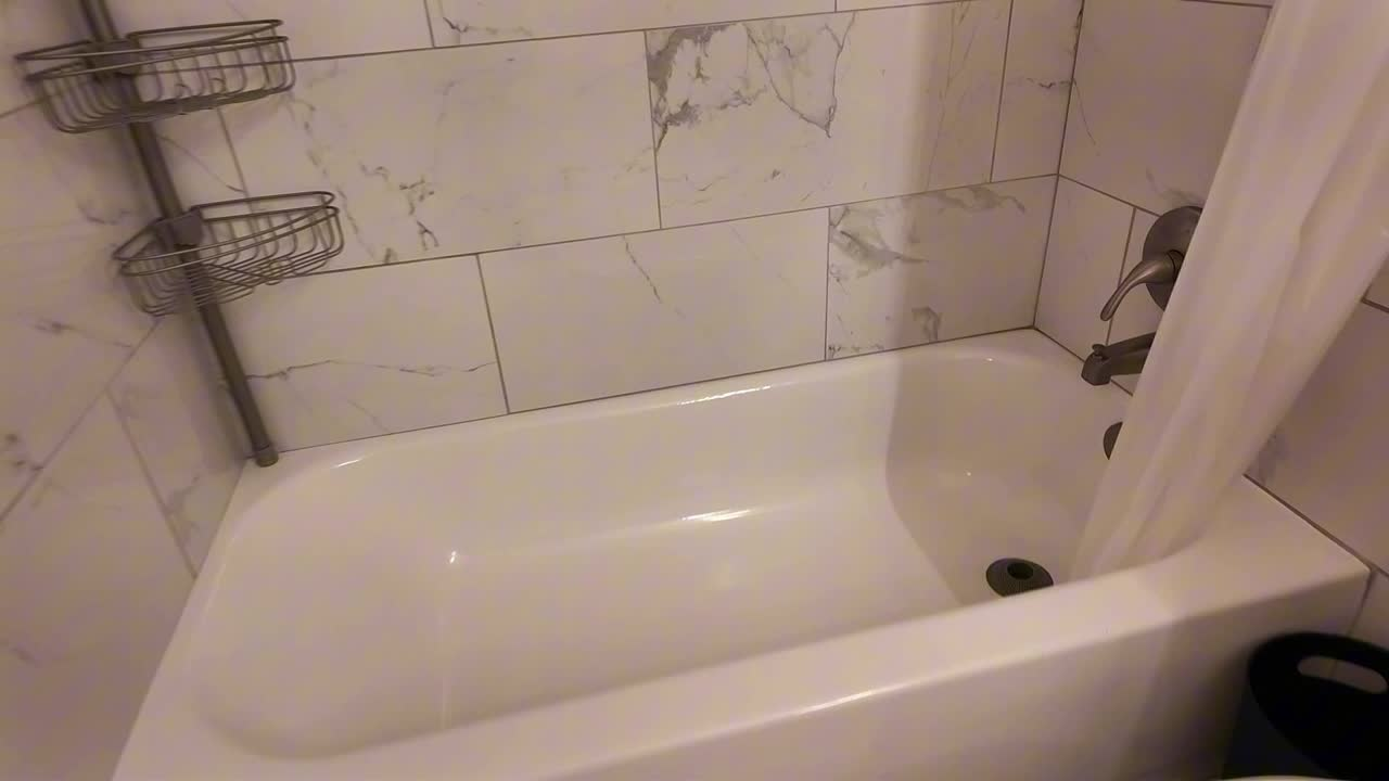 Rebuilt tub-shower with marble-look tile in the second bathroom at 4274 Rollingstone Drive, Las Vegas 89103
