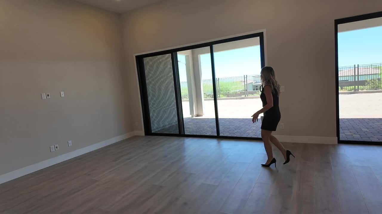 Amy Arbeli walking to the 12-foot slider and covered patio in the new construction Summerlin home with the $249,000 price cut