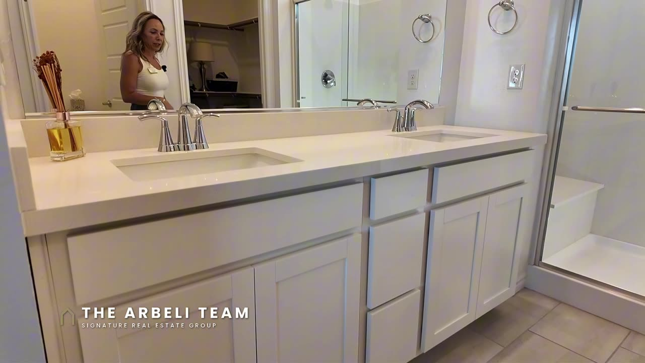 Primary bath with double sinks and a step-in shower with bench in a Heritage at Stonebridge home, Summerlin 89138