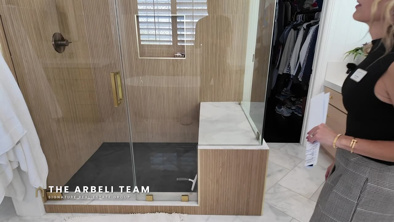 Renovated primary shower with wood-look tile and gold accents, Summerlin West home tour
