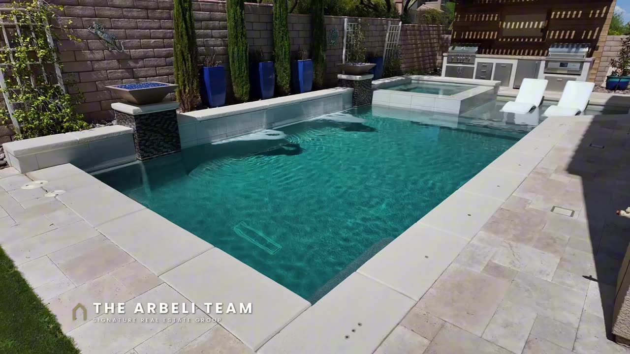 Pool with spill-over spa, tanning ledge and covered patio at a Paseos Summerlin home
