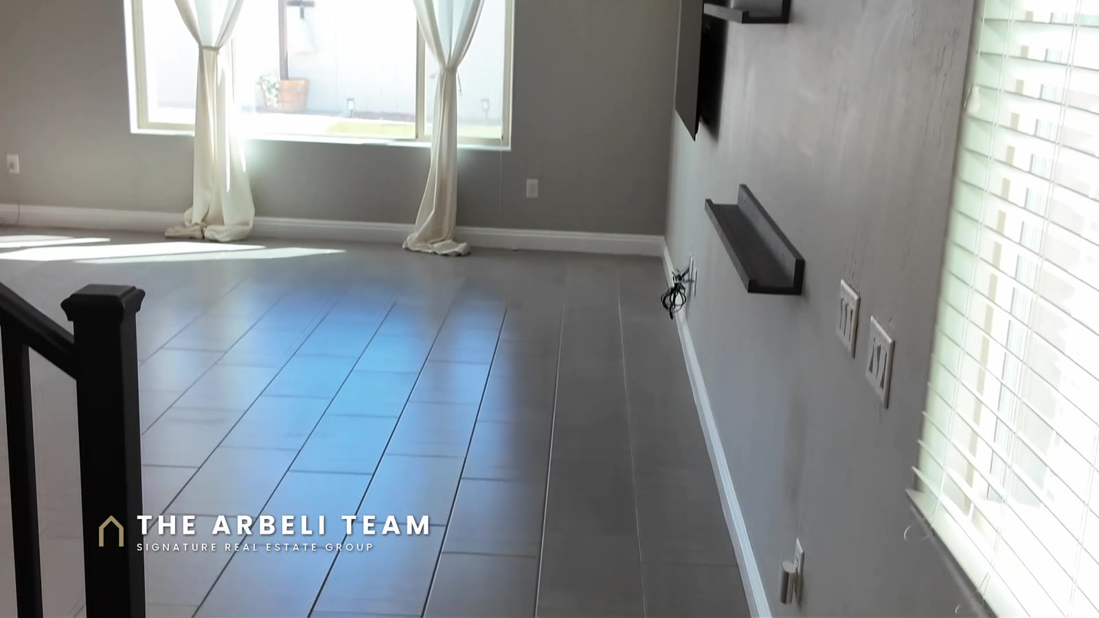 Vacant great room with tile flooring and drapes at 7204 Site Street, a move-in ready home in gated Mateo, Las Vegas 89113