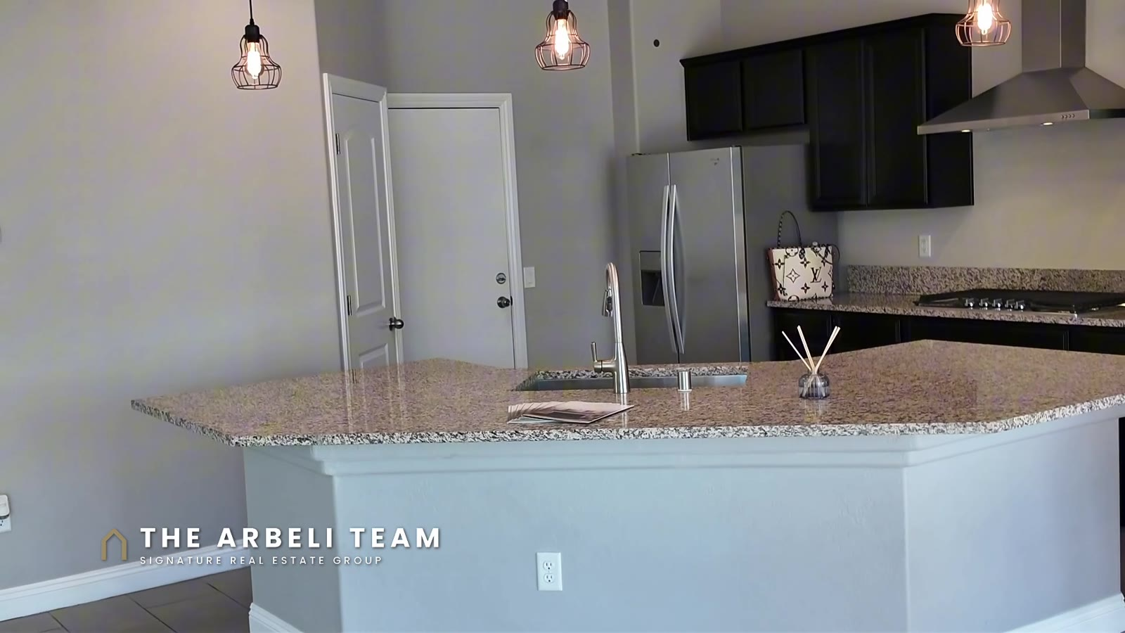 Kitchen island with granite counters and pendant lights at 7204 Site Street in southwest Las Vegas