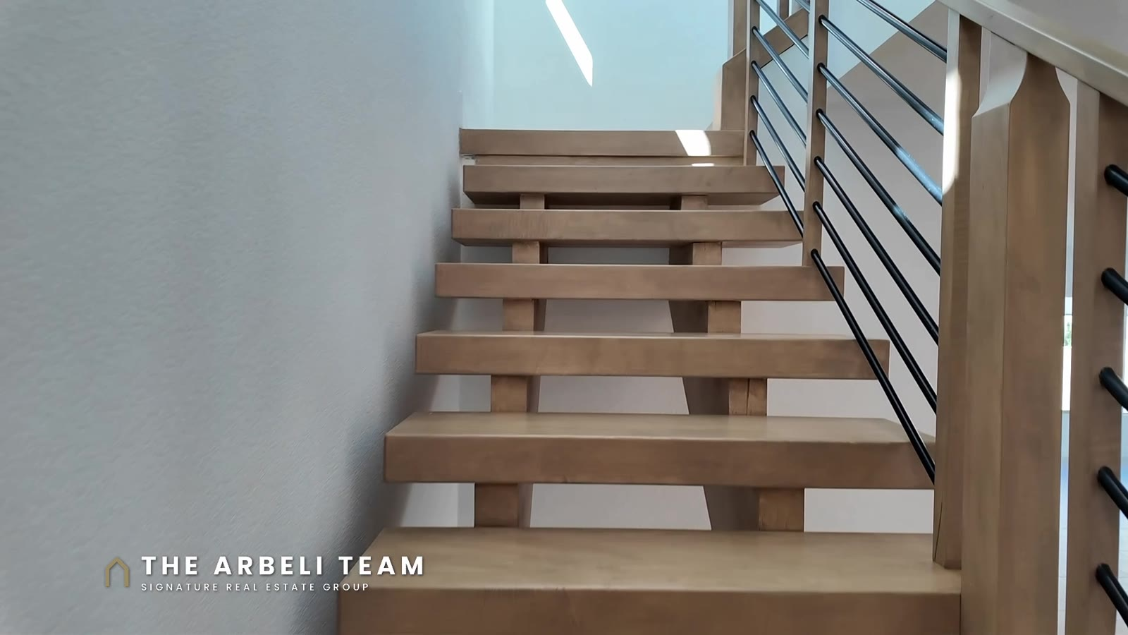 Floating wood stairs with a black horizontal railing in a Tri Pointe Plan 3 at Aberdeen Collection II, Las Vegas 89138