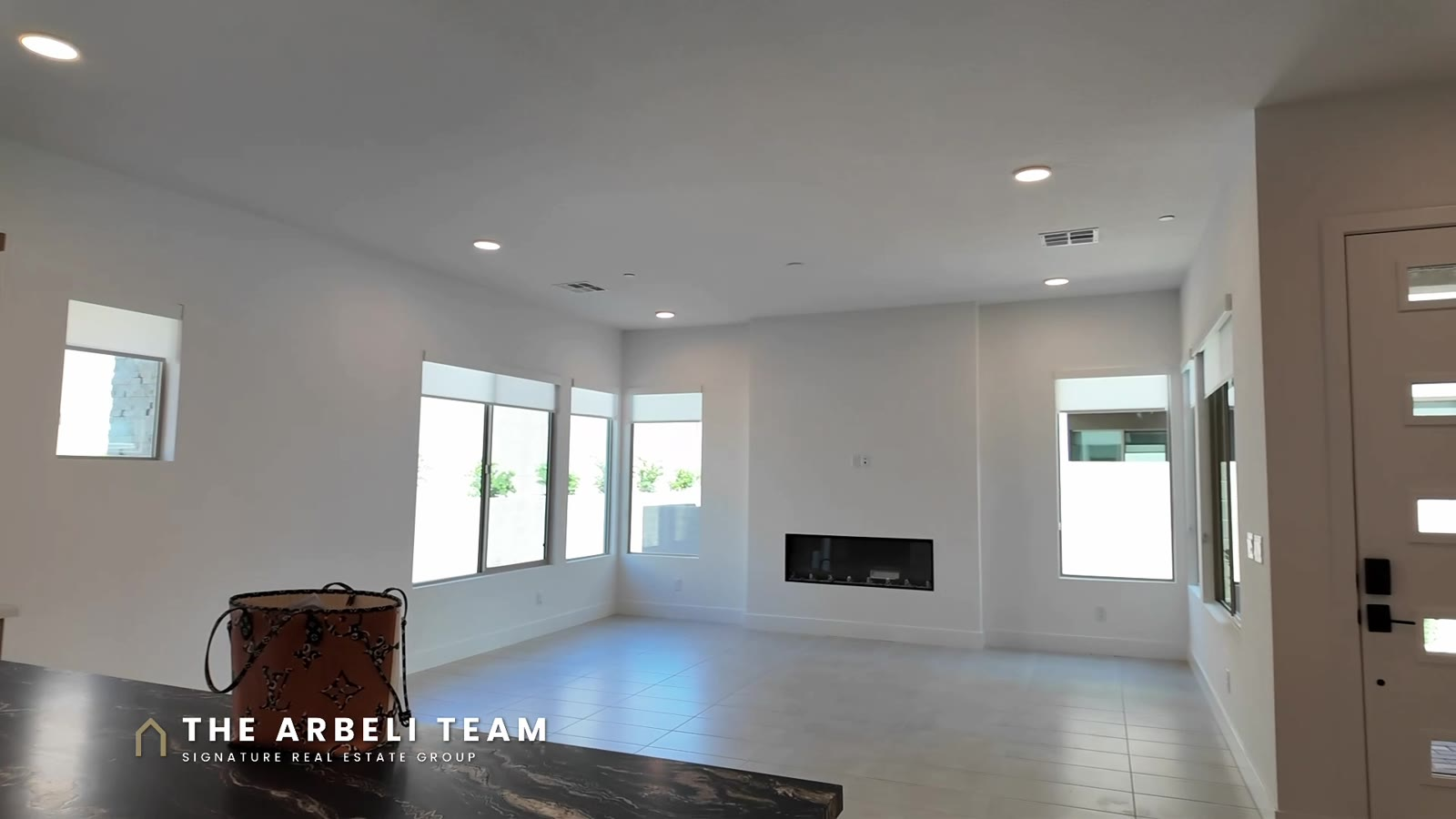 Great room with an electric fireplace and windows to the courtyard in a Tri Pointe Plan 3 at Aberdeen, Summerlin West