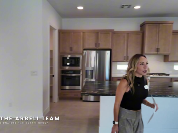 Island kitchen with wood cabinetry and GE appliances in a move-in ready Tri Pointe Plan 3 at Aberdeen Collection II, Summerlin West