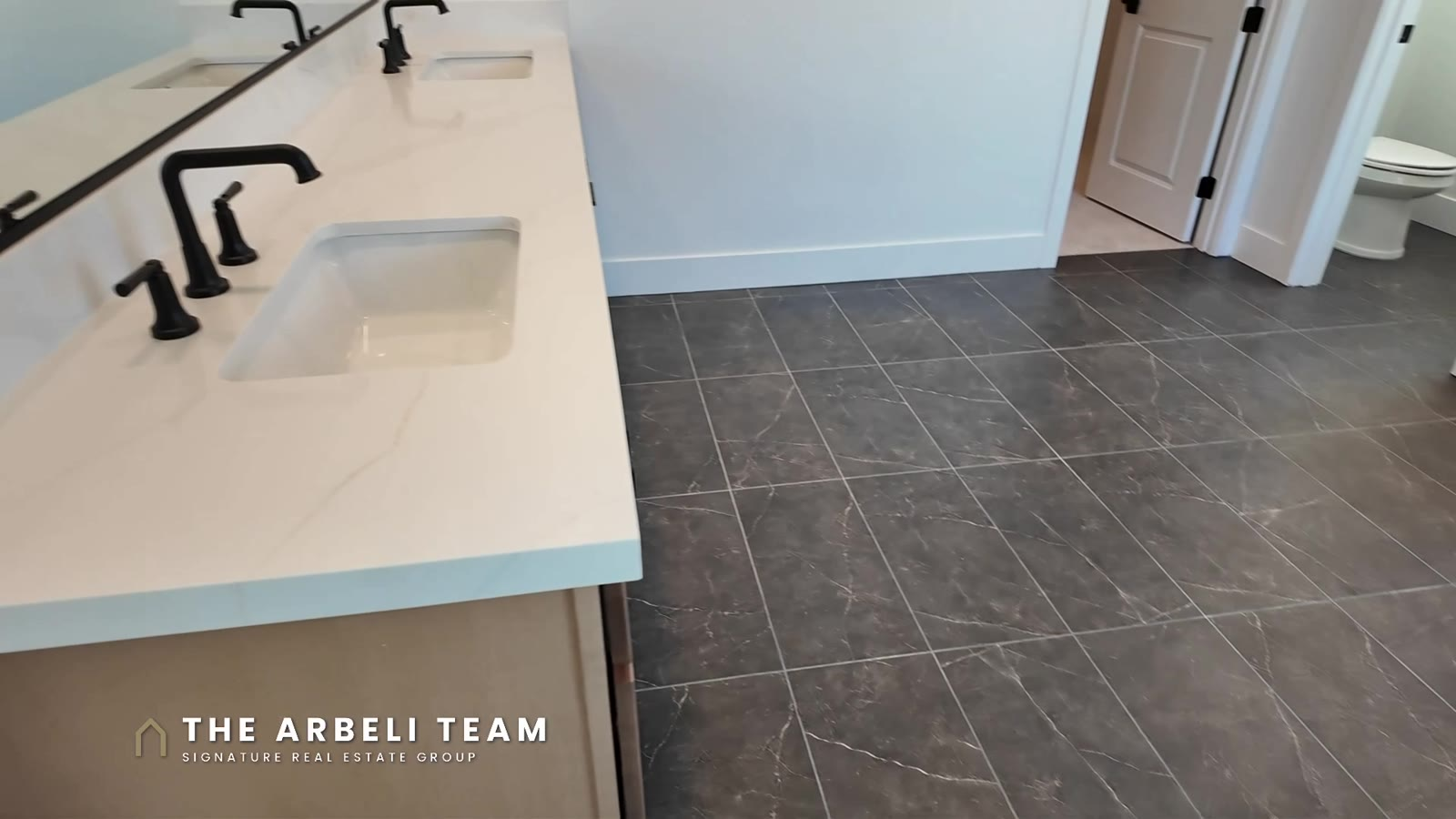 Primary bath with double sinks, matte black fixtures and a patterned tile floor in a Tri Pointe Plan 3 at Aberdeen, Las Vegas